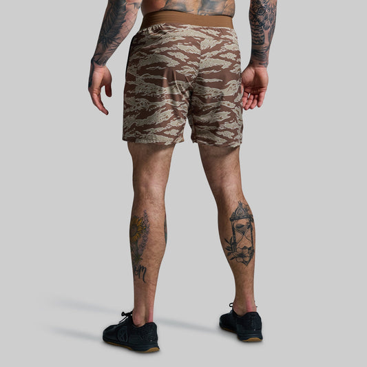 Person wearing camouflage shorts on a plain background