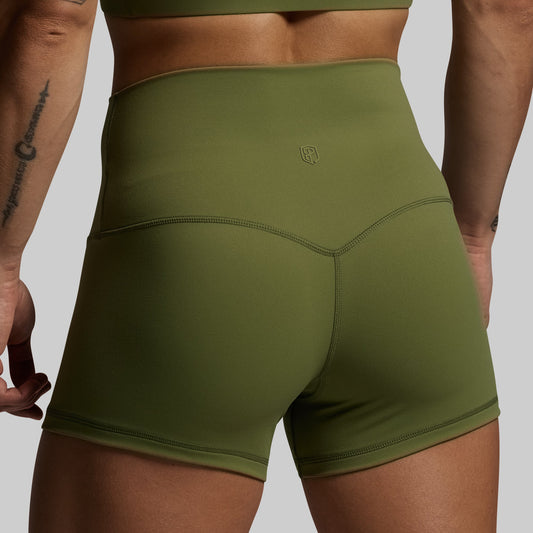 Green athletic shorts worn by a person on a plain background