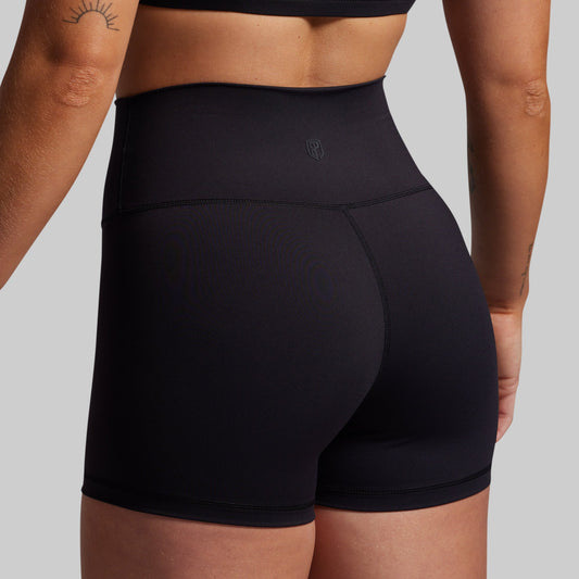 Black athletic shorts worn by a person on a plain background
