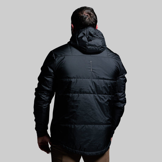 Person wearing a black puffer jacket on a gray background
