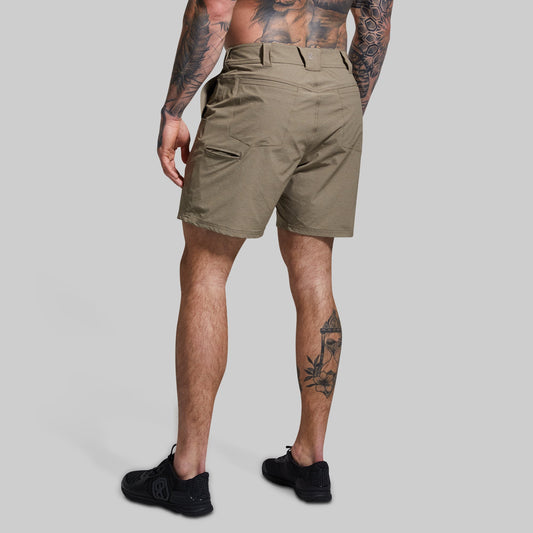 Person wearing khaki shorts on a gray background