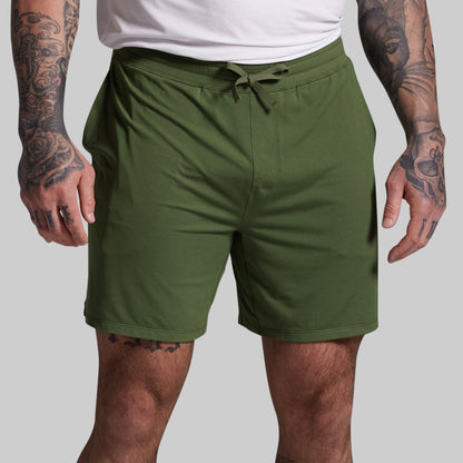 Person wearing green shorts on a plain background