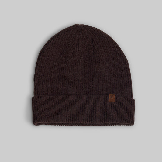 A dark brown ribbed knit beanie hat with a small brown leather logo patch on the side, displayed against a neutral gray background.
