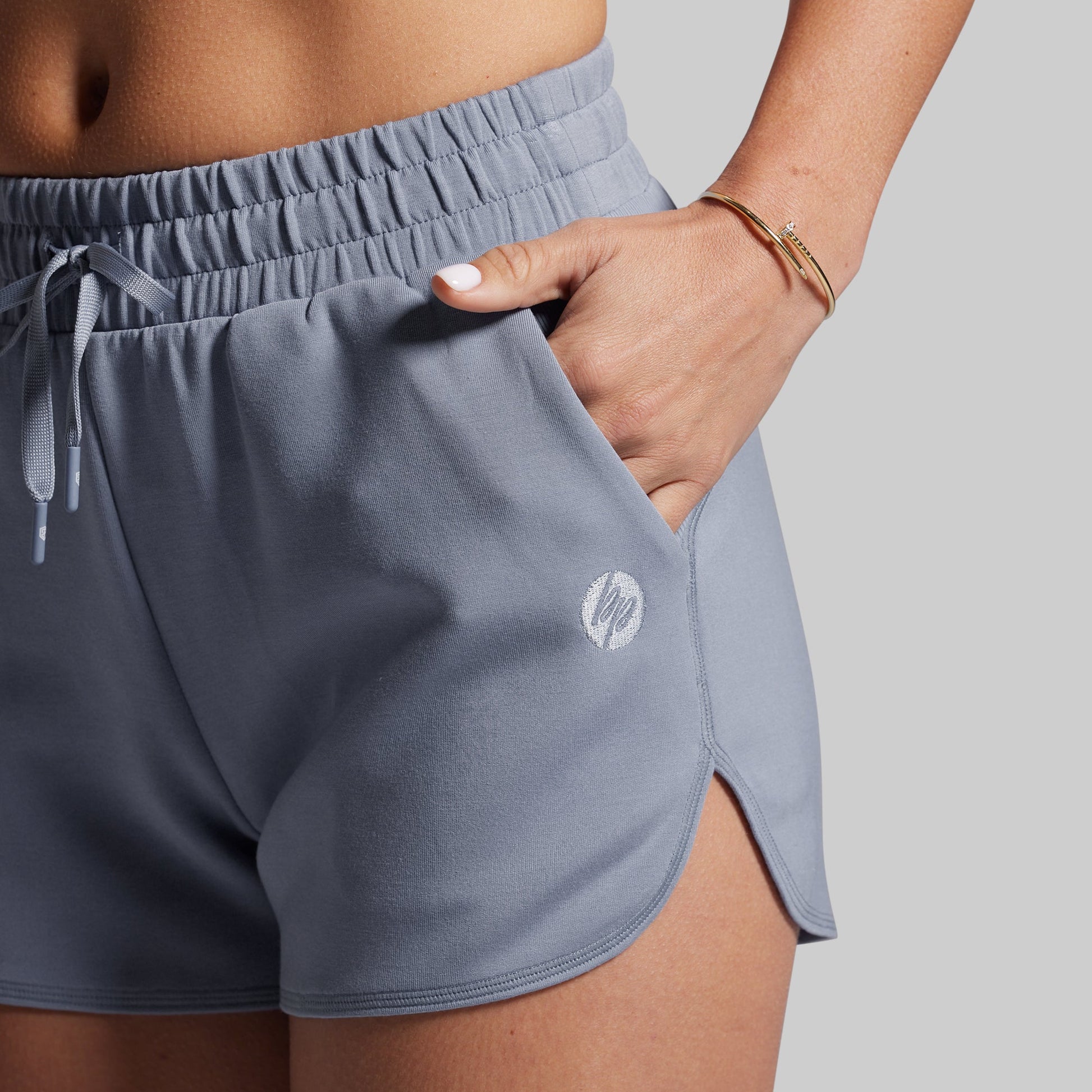 Gray athletic shorts with a brand logo on a neutral background