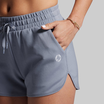 Gray athletic shorts with a brand logo on a neutral background