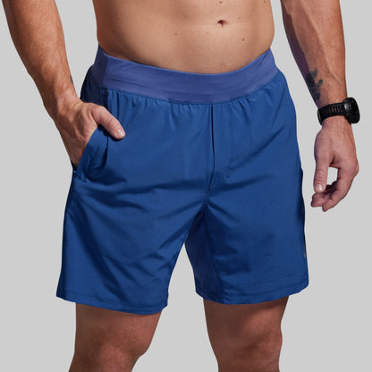Person wearing blue shorts on a plain background