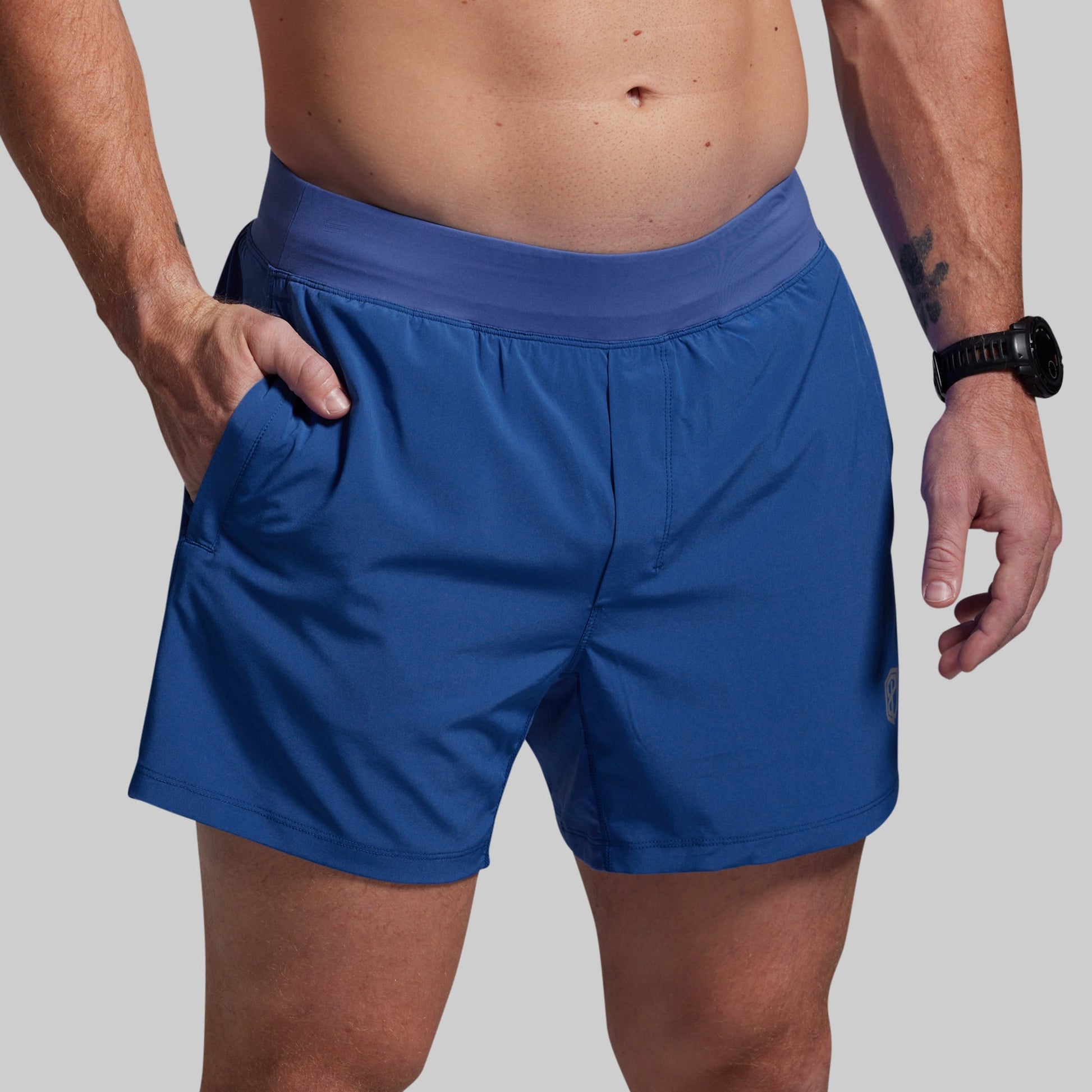Person wearing blue athletic shorts on a plain background