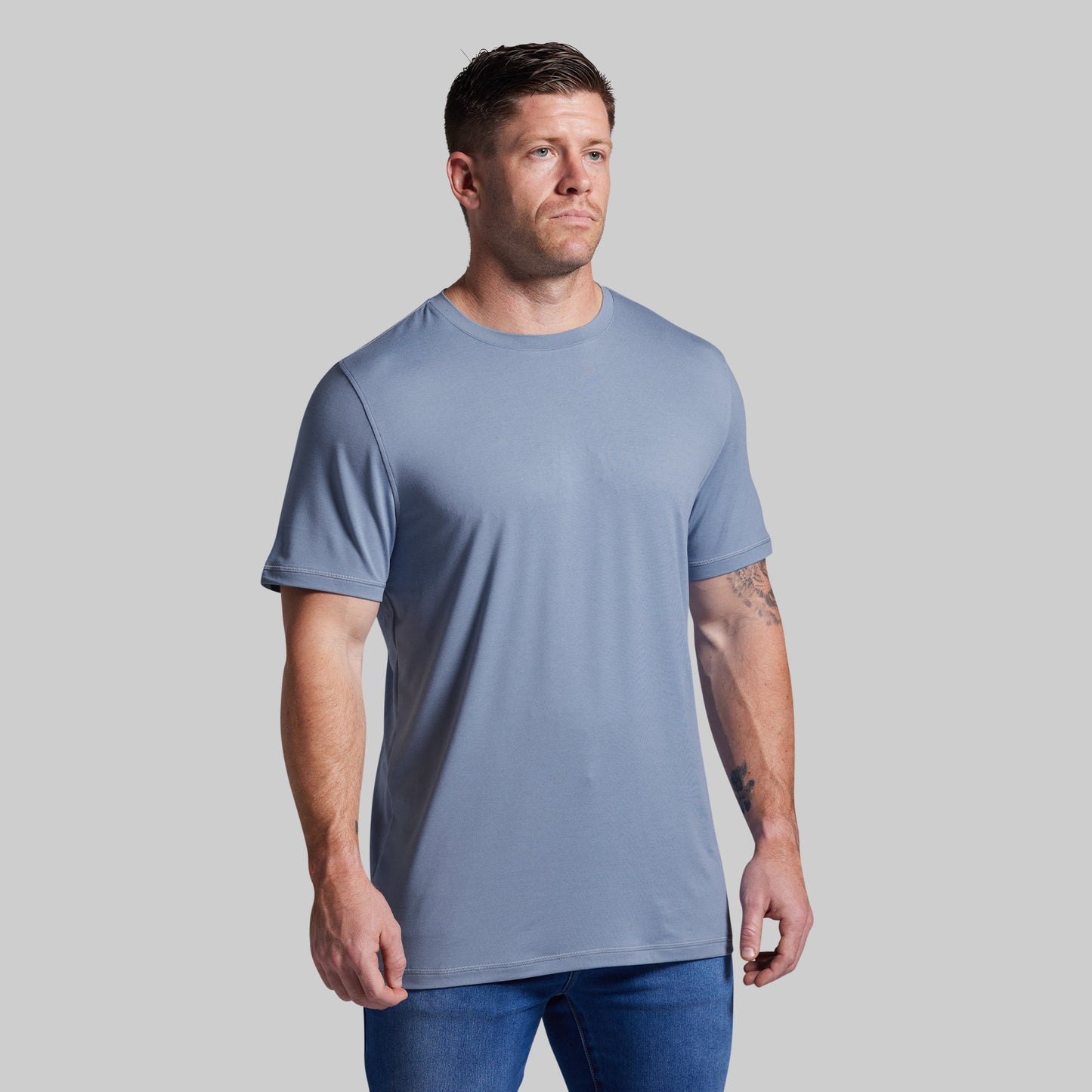 Man wearing a light blue t-shirt against a plain background