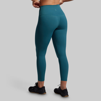 Teal leggings worn by a person on a gray background