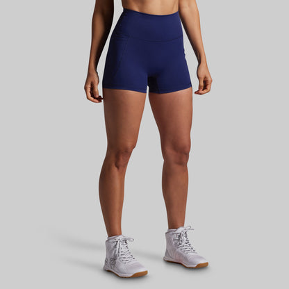 Person wearing navy blue athletic shorts on a gray background