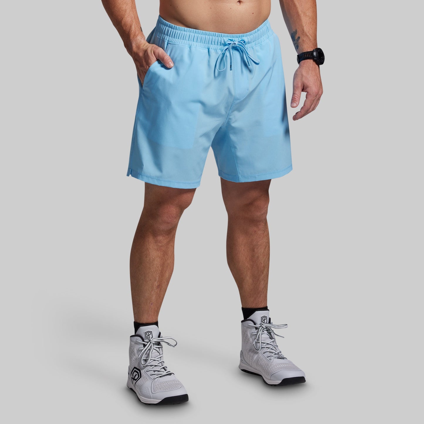 Person wearing light blue shorts on a gray background