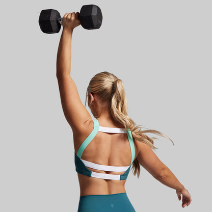 Woman lifting a dumbbell against a plain background