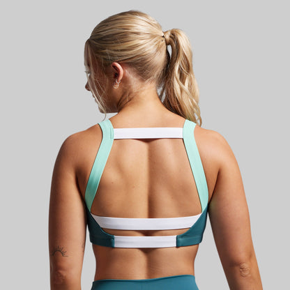 Woman wearing a sports bra and leggings on a gray background