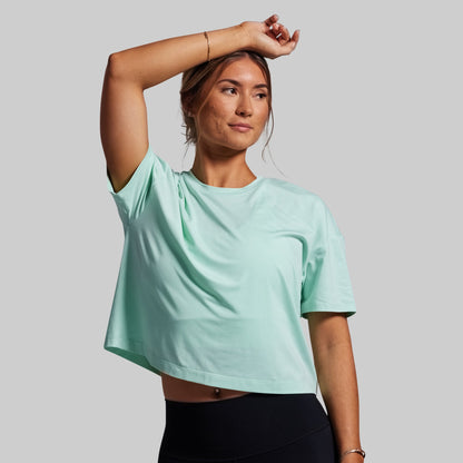 Person wearing a light blue t-shirt on a gray background