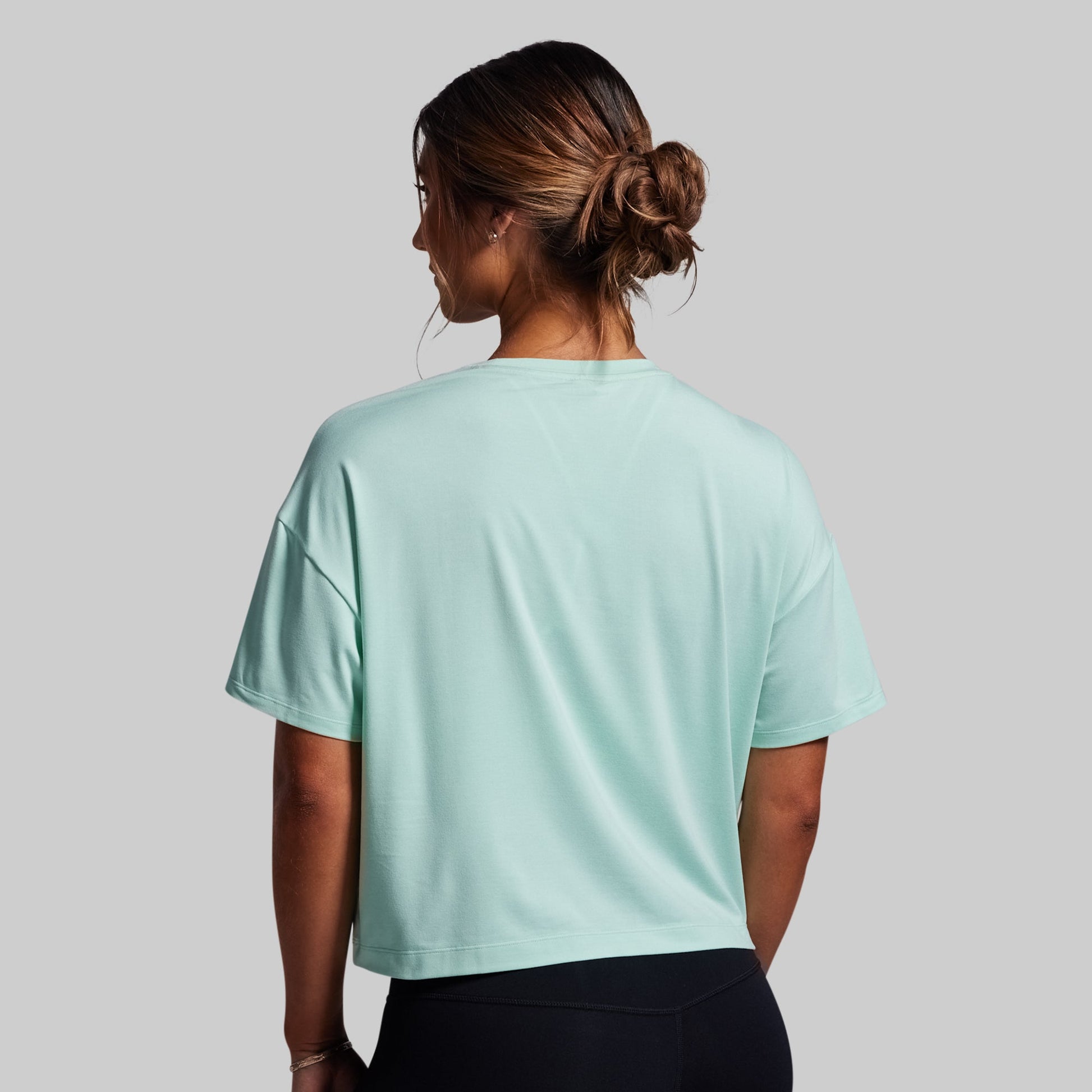 Person wearing a light blue t-shirt on a gray background