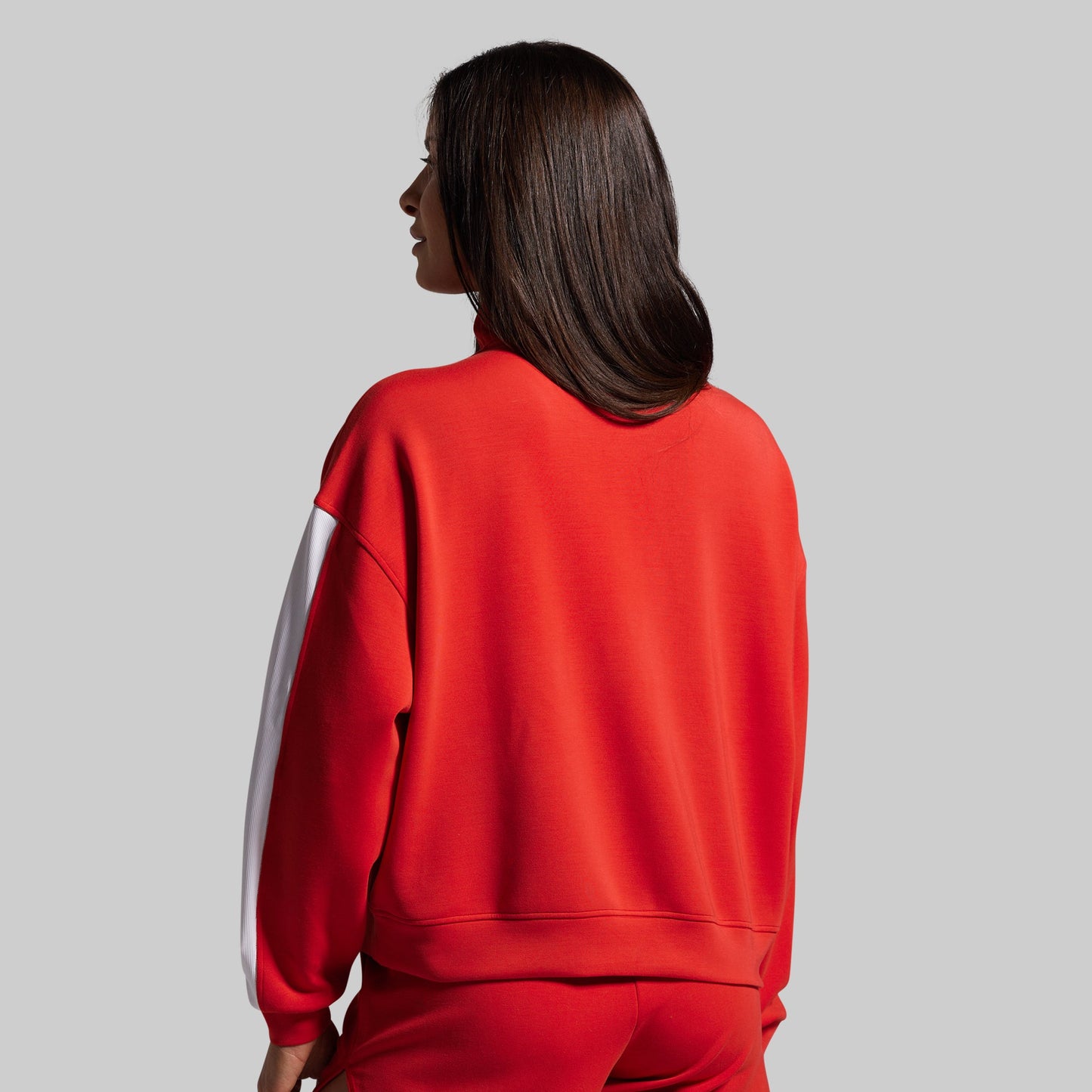 Person wearing a red outfit with a white stripe on a gray background