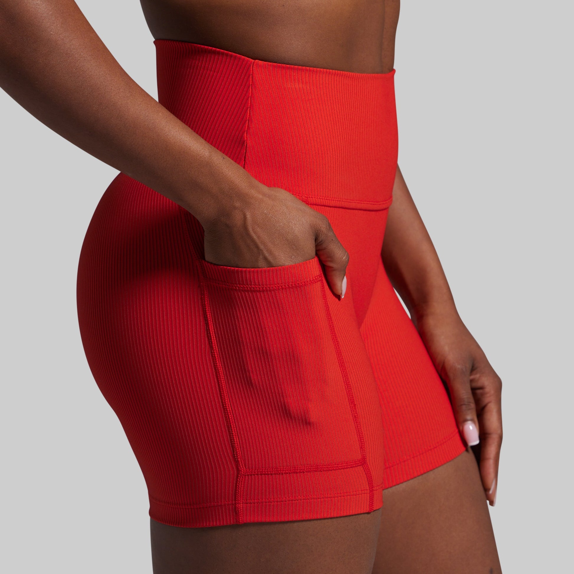 Red athletic shorts worn by a person on a gray background
