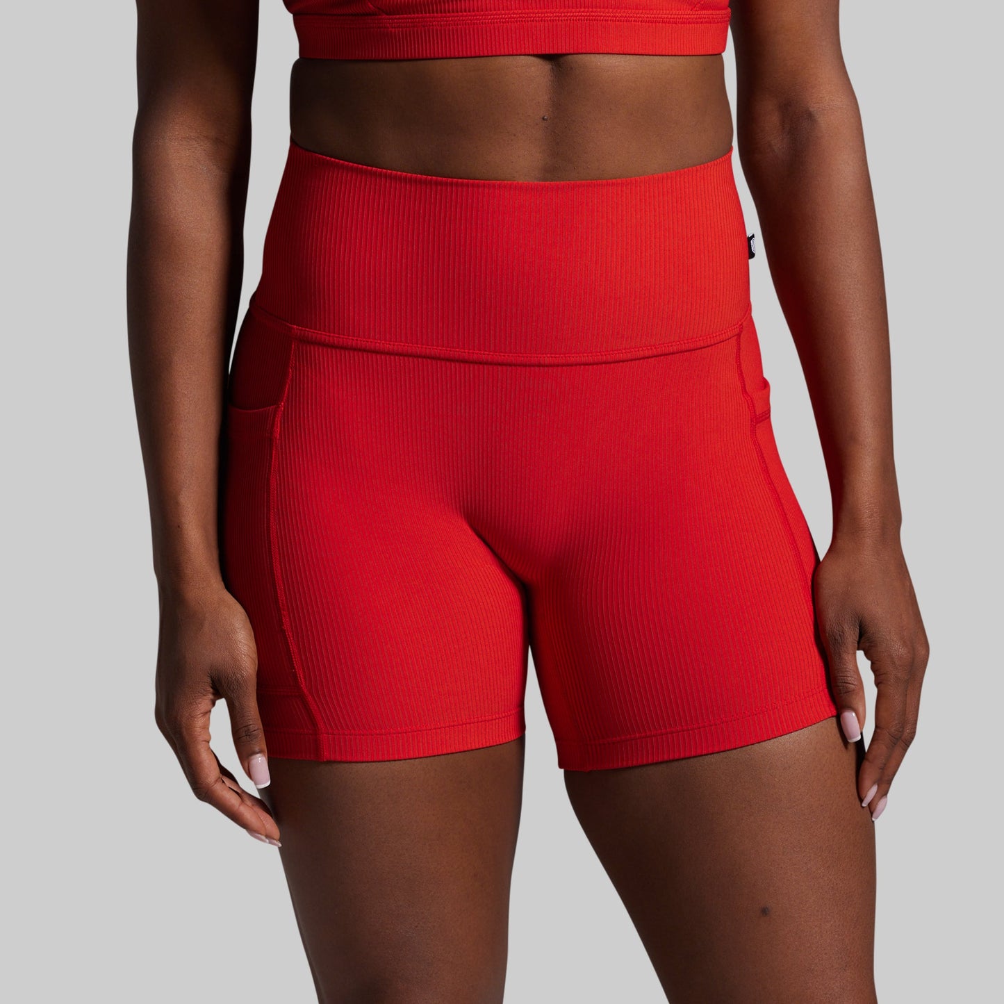 Red athletic shorts worn by a person on a gray background