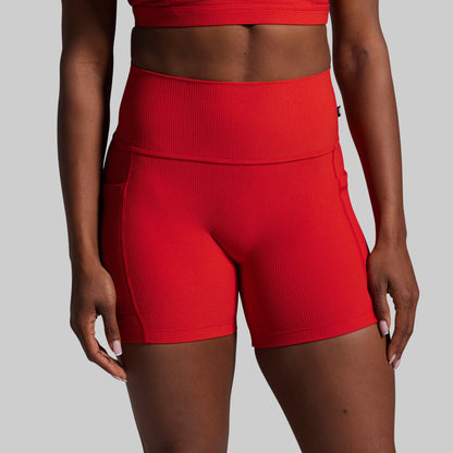 Red athletic shorts worn by a person on a gray background