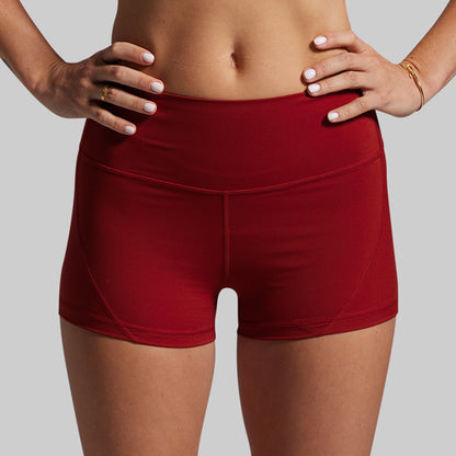 Red athletic shorts worn by a person on a gray background