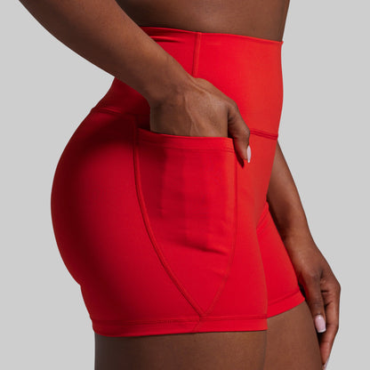 Red athletic shorts worn by a person on a gray background