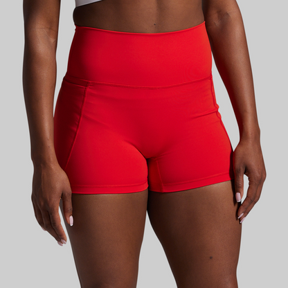 Red high-waisted shorts worn by a person on a gray background