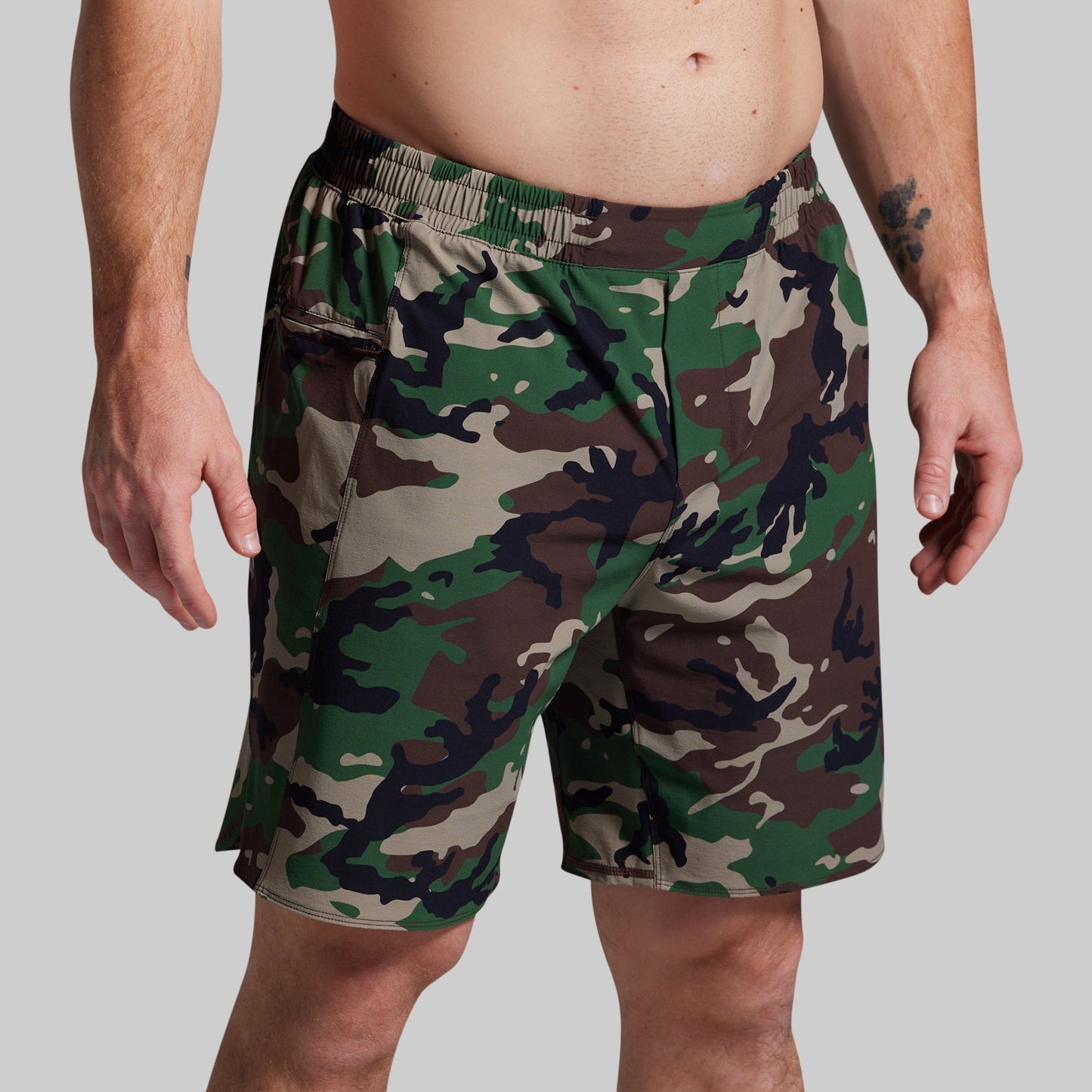 Camouflage shorts worn by a person on a plain background