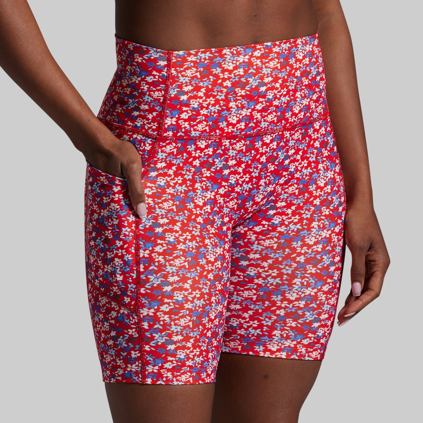 Red floral shorts worn by a person on a gray background