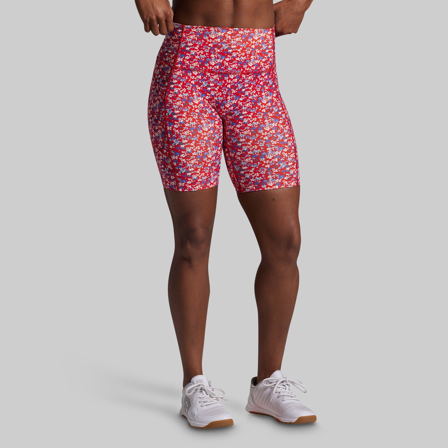 Person wearing red and blue patterned shorts on a gray background