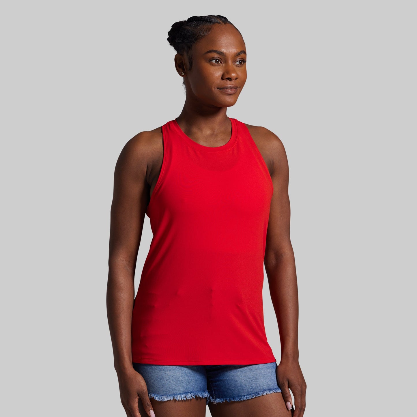 Woman wearing a red tank top against a gray background