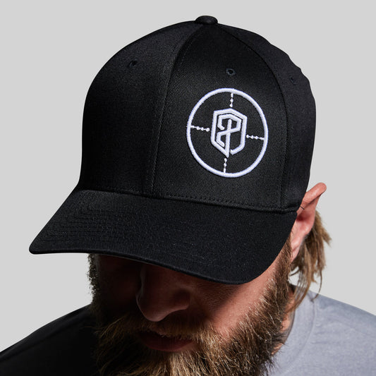 Person wearing a black cap with a white logo on a gray background