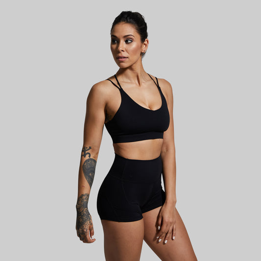 Woman wearing a black sports bra against a plain background