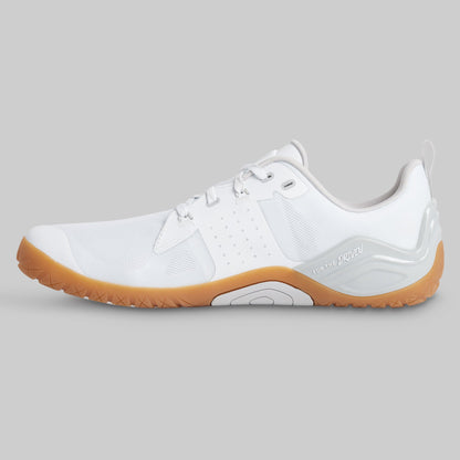 A white minimalist trainer shoe with a gum brown sole, shown in a side profile view against a solid gray background.