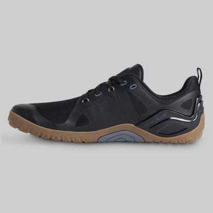 A black athletic shoe with a brown gum sole, shown in a side profile view against a solid gray background.