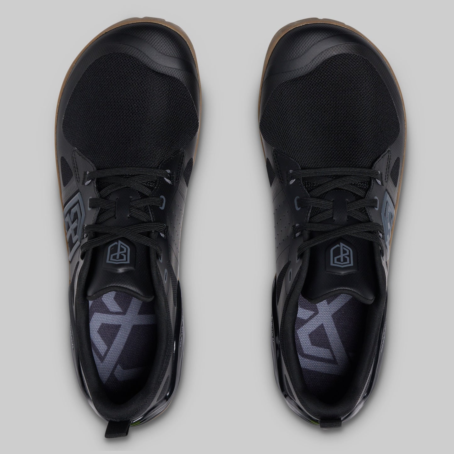 A pair of black low-top athletic shoes shown from a top-down view on a light gray background.
