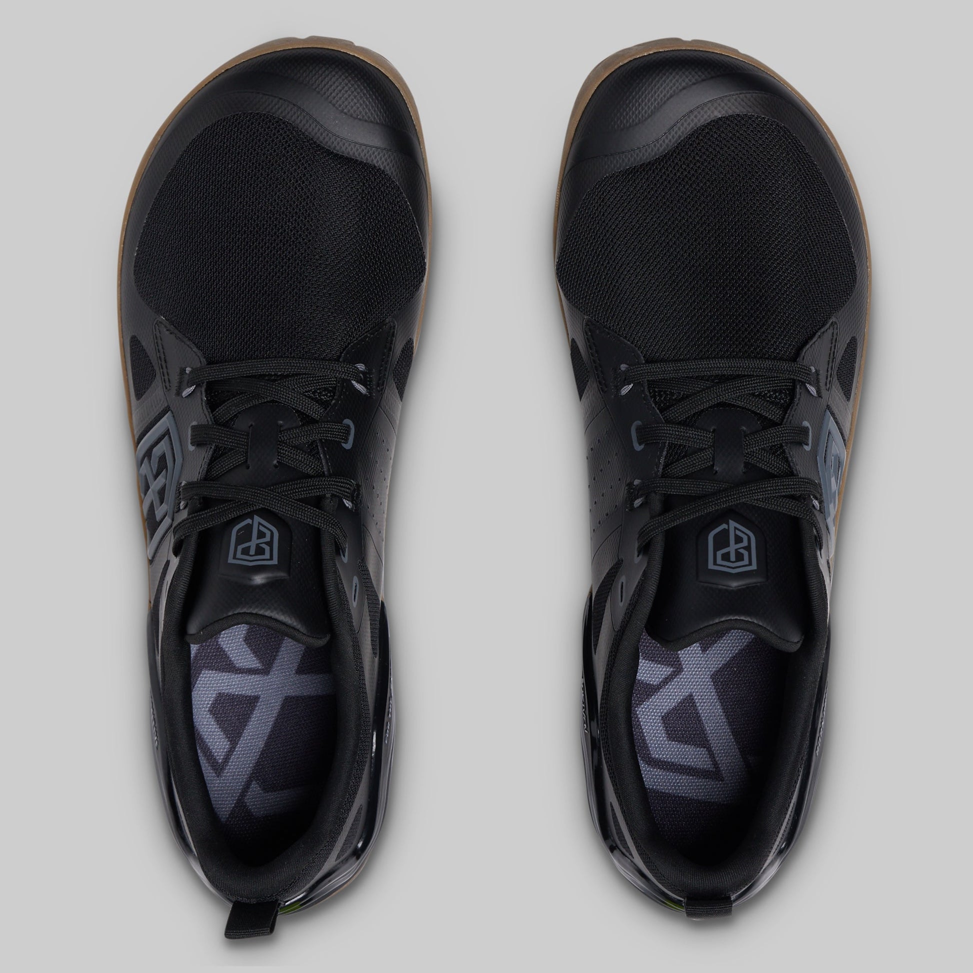 A pair of black low-top athletic shoes shown from a top-down view on a light gray background.