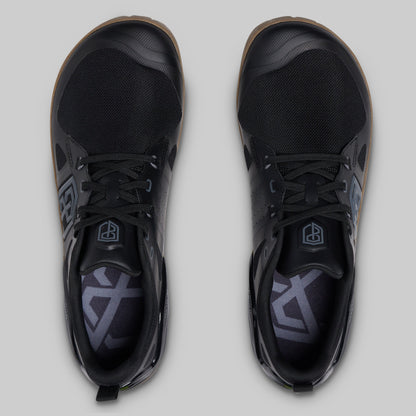 A pair of black low-top athletic shoes shown from a top-down view on a light gray background.