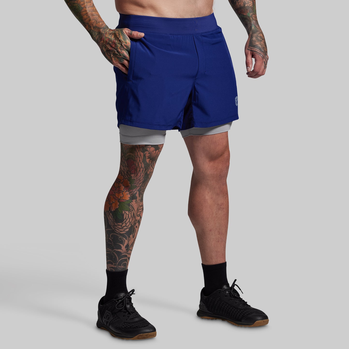 Person wearing blue athletic shorts on a gray background