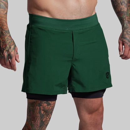 Person wearing green athletic shorts on a plain background