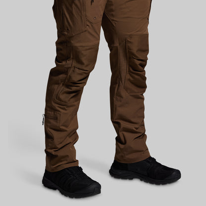 Brown tactical pants with black shoes on a light gray background