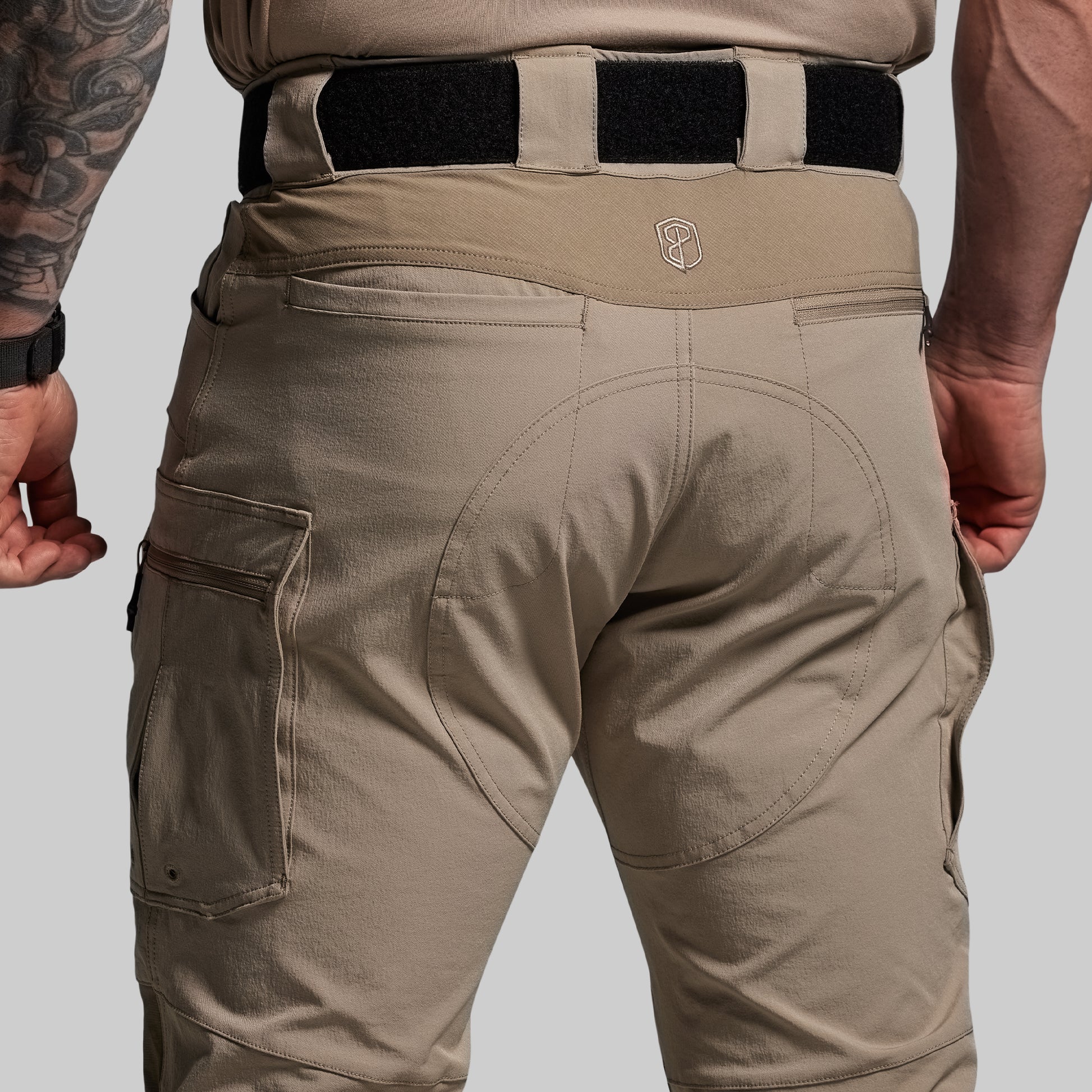 Beige tactical pants with a visible brand logo on a gray background