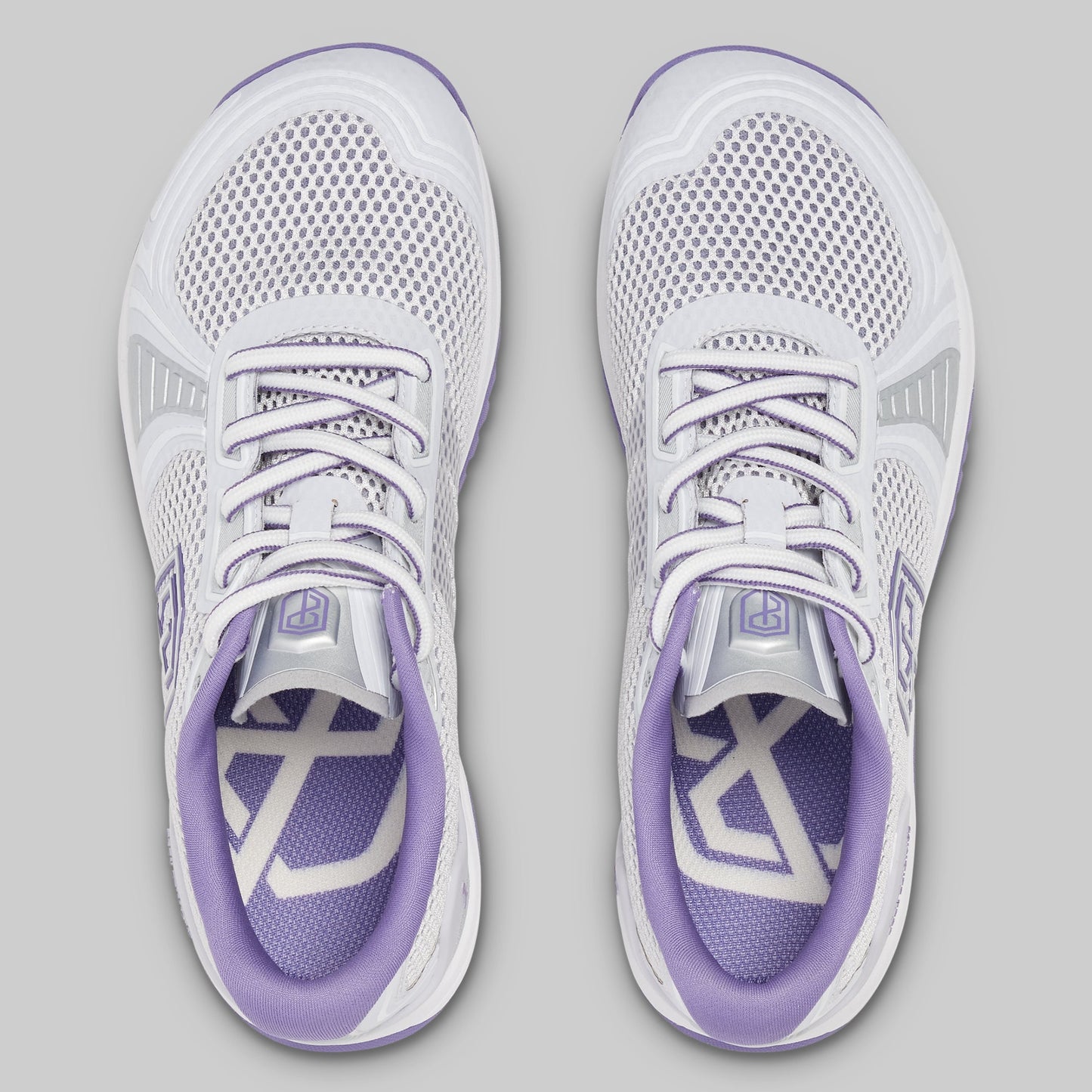 White and purple running shoes on a gray background