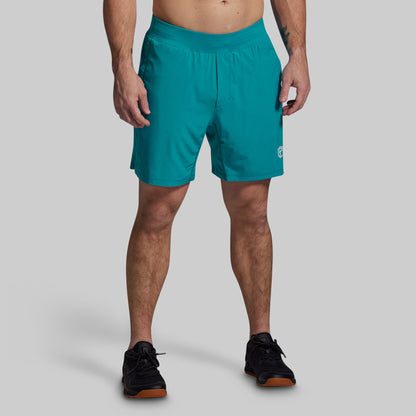 Person wearing teal shorts on a gray background