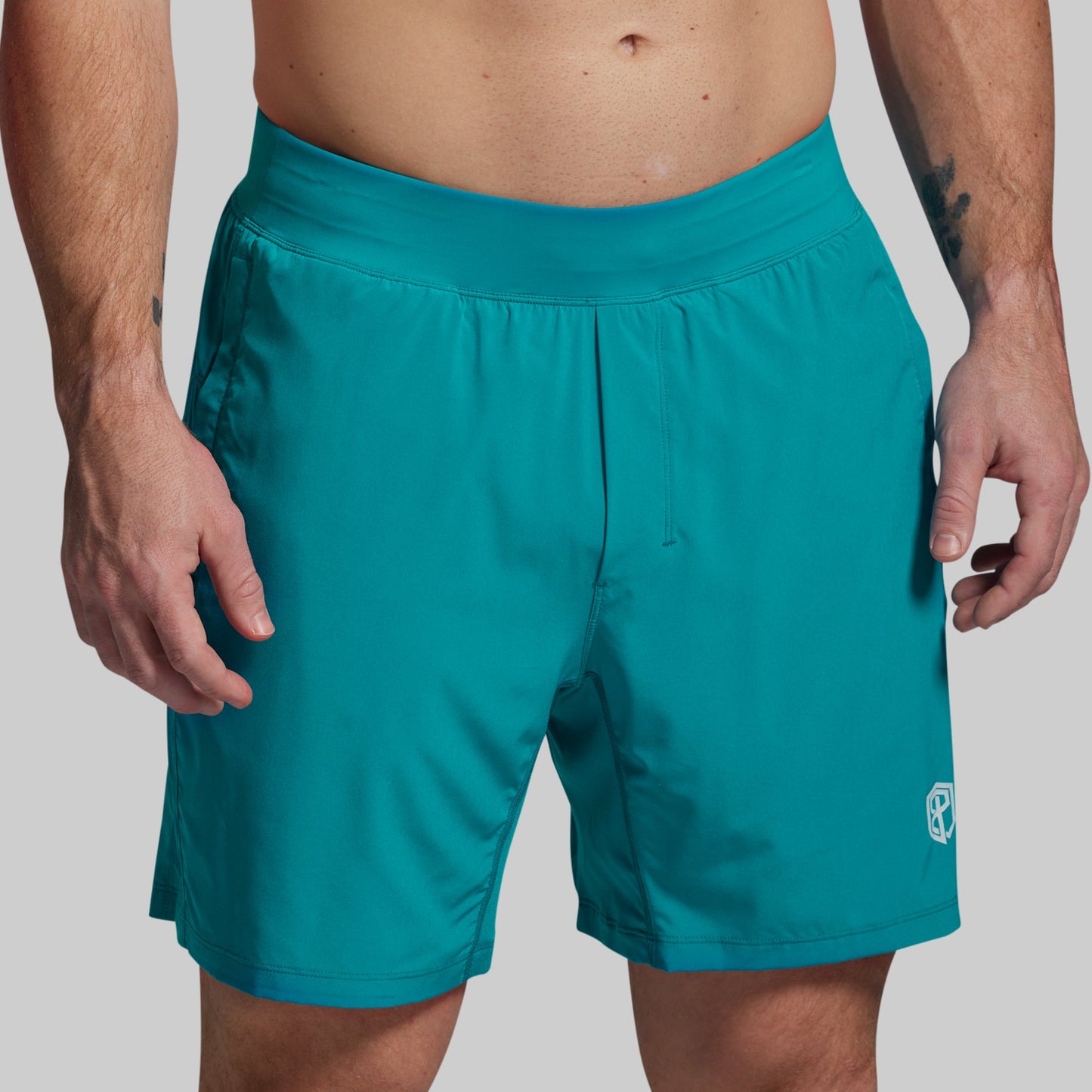 Teal shorts worn by a person on a plain background