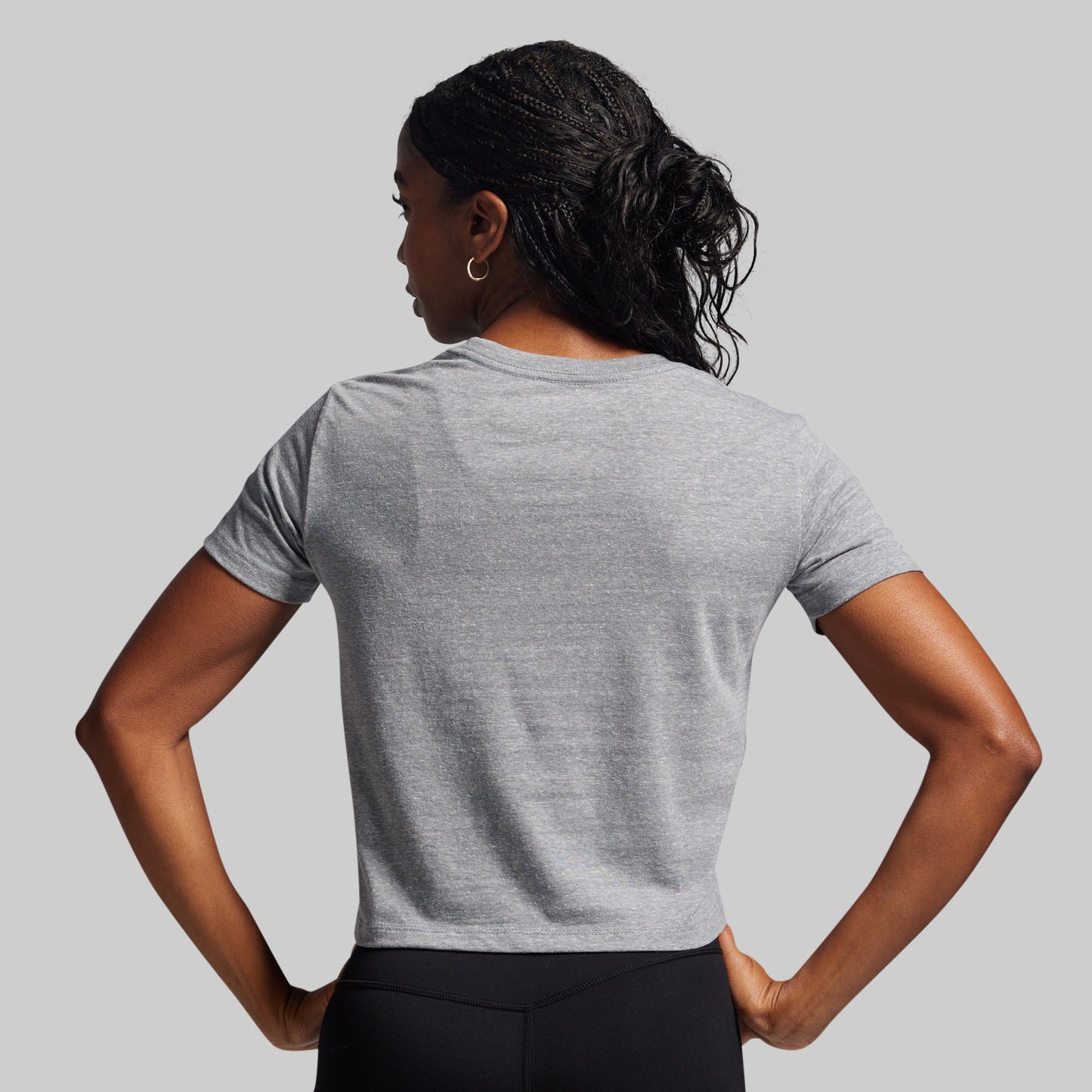 Woman wearing a gray t-shirt against a plain background