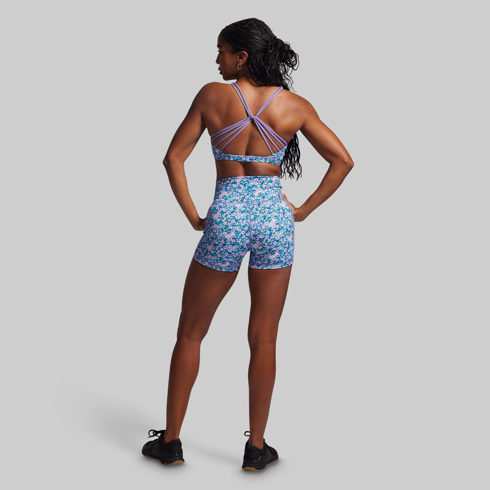 Woman wearing a floral sports outfit on a gray background