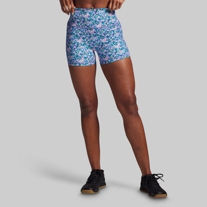 Person wearing colorful floral shorts on a gray background