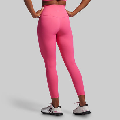 Person wearing bright pink leggings on a gray background