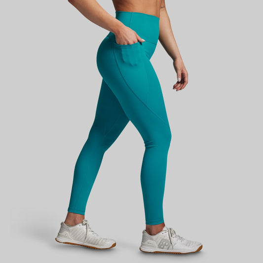 Teal leggings worn by a person on a gray background