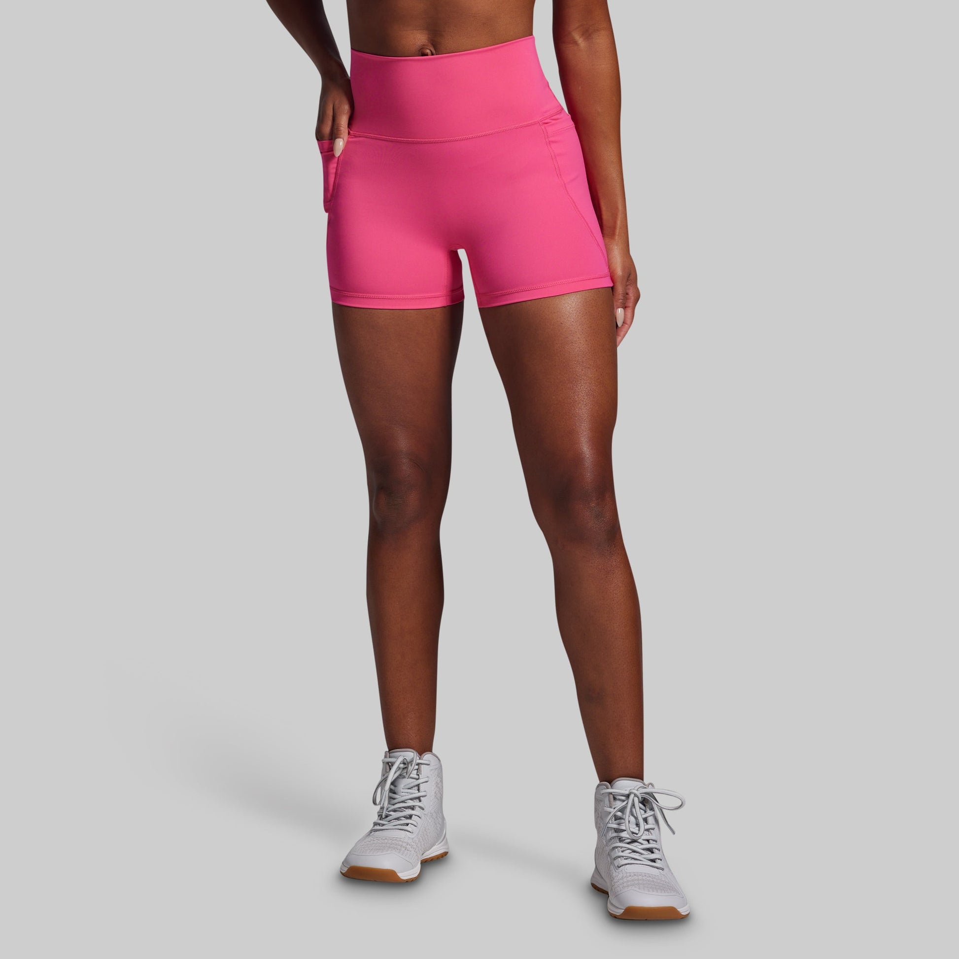 Person wearing pink athletic shorts on a gray background